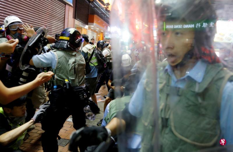 香港镇暴警察前晚在旺角试图驱散示威者时,有警员用盾牌推撞在场记者。(路透社) 香港镇暴警察前晚在旺角试图驱散示威者时,有警员用盾牌推撞在场记者。(路透社)