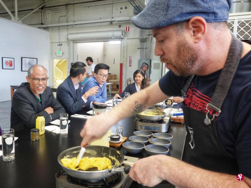 环境及水源部长马善高(左一)在美国食品科技公司JUST现场观察工作人员用绿豆蛋白质做的鸡蛋代替品烹煮美式炒蛋。(取自马善高面簿) 环境及水源部长马善高(左一)在美国食品科技公司JUST现场观察工作人员用绿豆蛋白质做的鸡蛋代替品烹煮美式炒蛋。(取自马善高面簿)