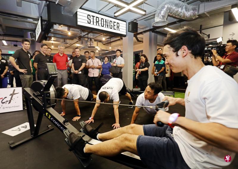 李显龙总理(后排左三)和贸工部长陈振声(后排左二)参观imPAct@芳林公园的设施,包括图中新增设的健身房,让商业区专业人员下班后就近运动。(邝启聪摄) 李显龙总理(后排左三)和贸工部长陈振声(后排左二)参观imPAct@芳林公园的设施,包括图中新增设的健身房,让商业区专业人员下班后就近运动。(邝启聪摄)