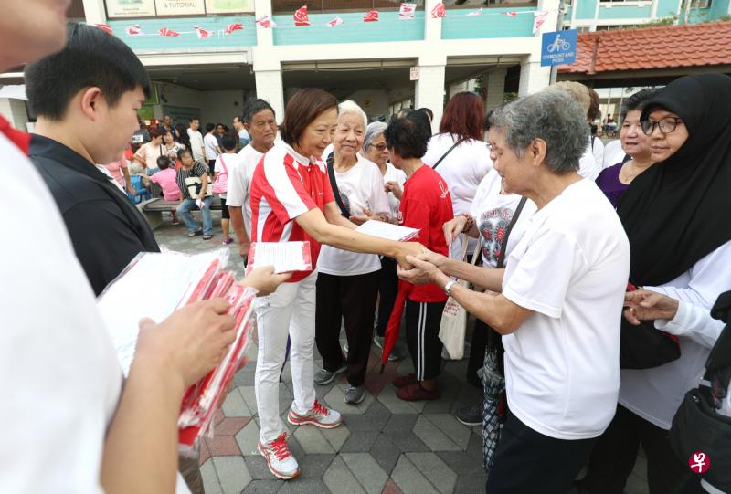 义顺集选区议员李美花(中)向居民分发国旗,让他们在国庆期间张挂国旗,增添国庆气氛。(林泽锐摄) 义顺集选区议员李美花(中)向居民分发国旗,让他们在国庆期间张挂国旗,增添国庆气氛。(林泽锐摄)