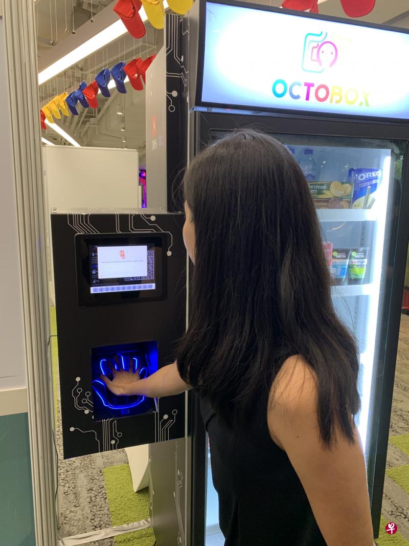 本地初创公司OCTOBOX研发的自动贩卖机仅利用掌纹便可完成购物付款。扫描手掌后,自动贩卖机的玻璃门将弹开,机器将在柜门关闭后自动从用户的电子钱包中扣款,完成无需现金、交易卡甚至手机的购物体验。(王晓亚摄) 本地初创公司OCTOBOX研发的自动贩卖机仅利用掌纹便可完成购物付款。扫描手掌后,自动贩卖机的玻璃门将弹开,机器将在柜门关闭后自动从用户的电子钱包中扣款,完成无需现金、交易卡甚至手机的购物体验。(王晓亚摄)