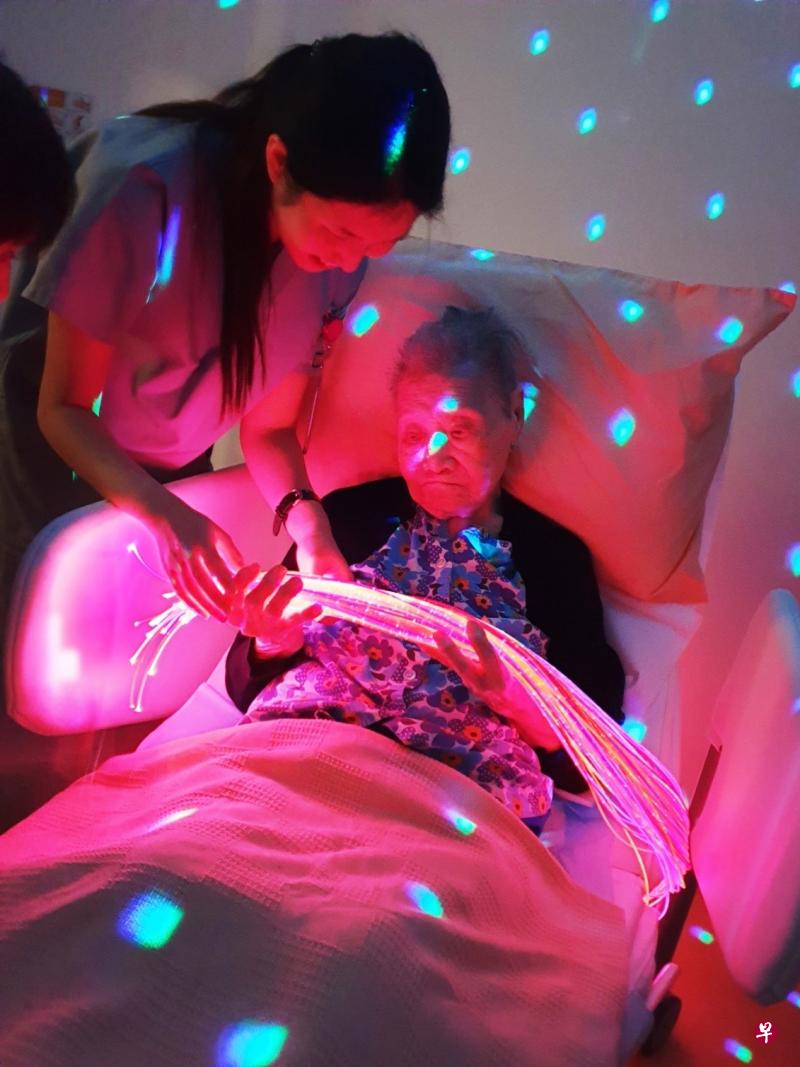 马里士他旺年护理之家治疗师让病患手握变色光纤束,刺激患者的视觉和触觉。(旺年护理之家提供) 马里士他旺年护理之家治疗师让病患手握变色光纤束,刺激患者的视觉和触觉。(旺年护理之家提供)