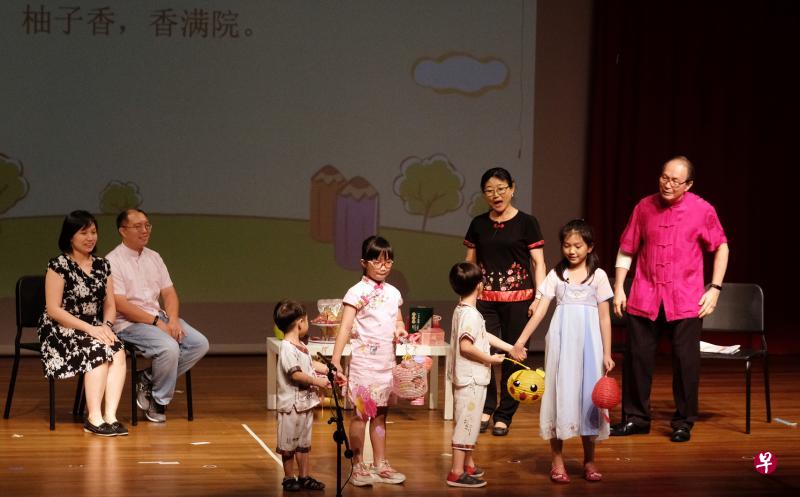 张亚凤(后排右二)出动一家三代人参加儿歌比赛,把平时家人庆祝中秋节的生活场景搬上舞台,让比赛气氛变得温馨起来。(曾坤顺摄) 张亚凤(后排右二)出动一家三代人参加儿歌比赛,把平时家人庆祝中秋节的生活场景搬上舞台,让比赛气氛变得温馨起来。(曾坤顺摄)