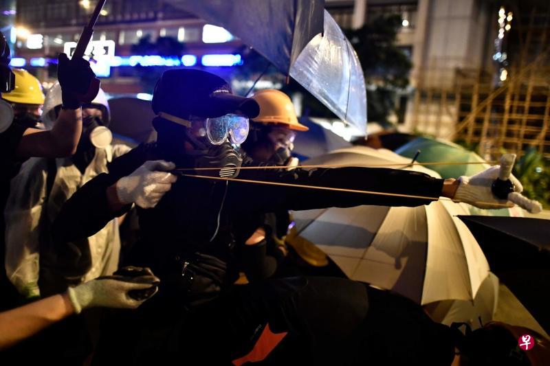 一名示威者昨晚用弹弓向警员发射石块。(法新社) 一名示威者昨晚用弹弓向警员发射石块。(法新社)