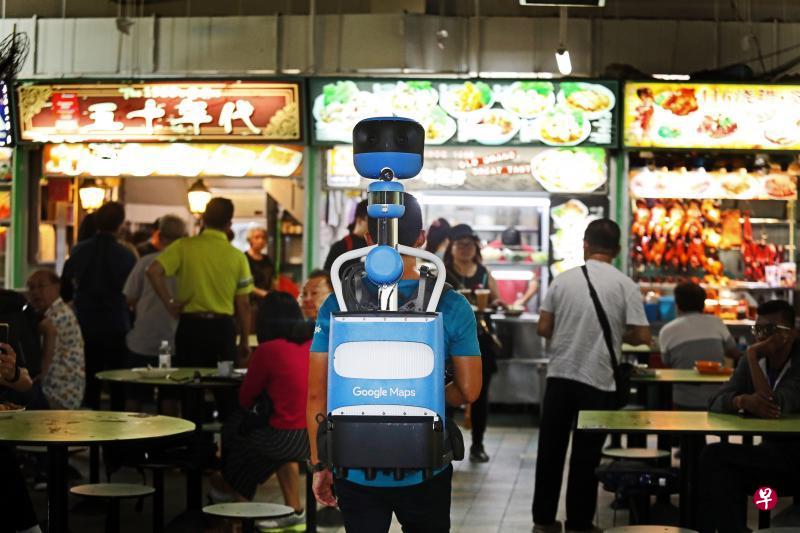 背着Trekker街景背包的谷歌工作人员走入牛车水大厦熟食中心,拍摄里面的200多个小贩摊位。(梁伟康摄) 背着Trekker街景背包的谷歌工作人员走入牛车水大厦熟食中心,拍摄里面的200多个小贩摊位。(梁伟康摄)
