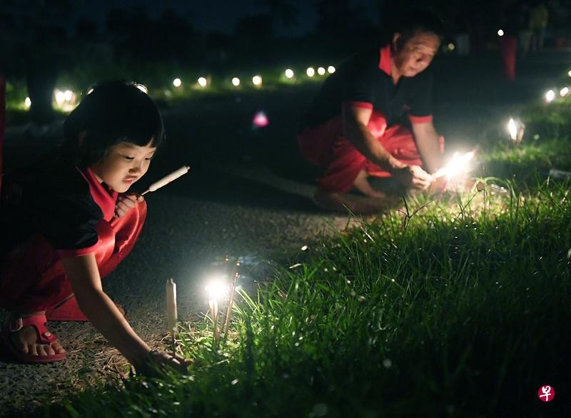 七岁女童帮忙在路旁插蜡烛,为祭拜仪式做准备。(蔡振鸿摄) 七岁女童帮忙在路旁插蜡烛,为祭拜仪式做准备。(蔡振鸿摄)