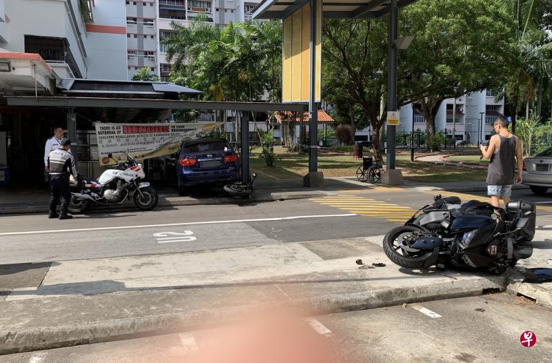 这辆深蓝色轿车疑车主误踩油门，失控往前冲，撞倒两辆电单车，其中一辆还卡在车底下。（邬福梁摄）