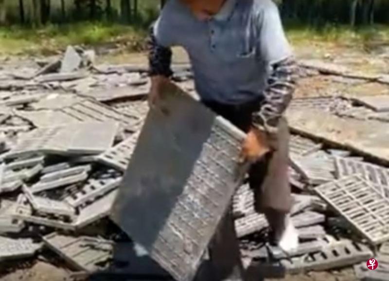 村名在搬运掉落的井盖(视频截图) 村名在搬运掉落的井盖(视频截图)