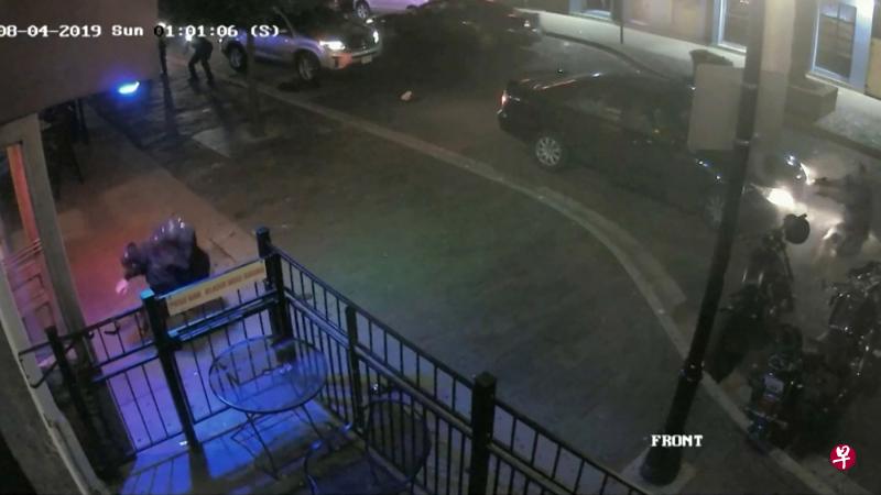 闭路电视画面显示，枪手贝茨在俄州代顿市一家夜店外，被一名警察（右）开枪打中后倒地。若非警方迅速击毙枪手，此案伤亡者恐怕更多。（路透社） 
