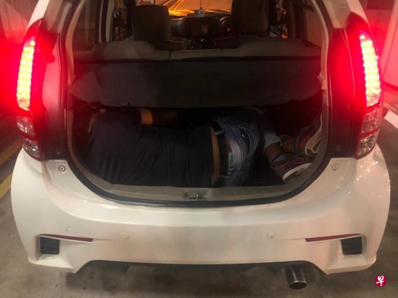 执法人员在兀兰关卡截查一辆马来西亚注册的轿车时,发现一名男子藏在后备箱内。(移民与关卡局提供) 执法人员在兀兰关卡截查一辆马来西亚注册的轿车时,发现一名男子藏在后备箱内。(移民与关卡局提供)