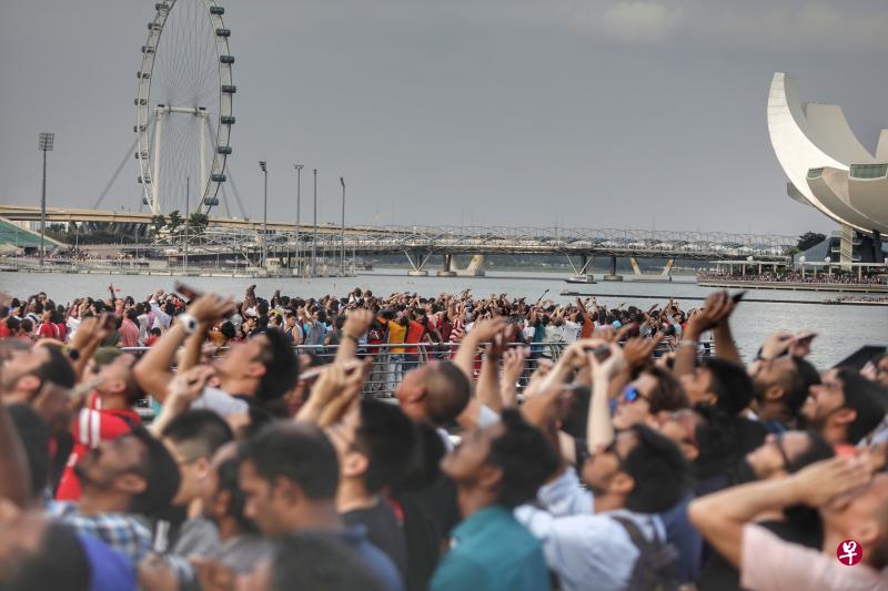 但凡海陆空出现任何风吹草动,滨海湾沿岸上万名来自国内外的观众便会整齐地转向声音来源方向,举起手中手机相机,焦灼等待惊喜出现。(林国明摄) 但凡海陆空出现任何风吹草动,滨海湾沿岸上万名来自国内外的观众便会整齐地转向声音来源方向,举起手中手机相机,焦灼等待惊喜出现。(林国明摄)