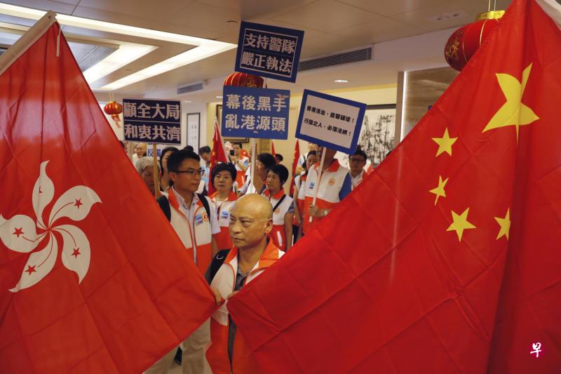 一名与会男士举着香港区旗和中国国旗。(美联社) 一名与会男士举着香港区旗和中国国旗。(美联社)