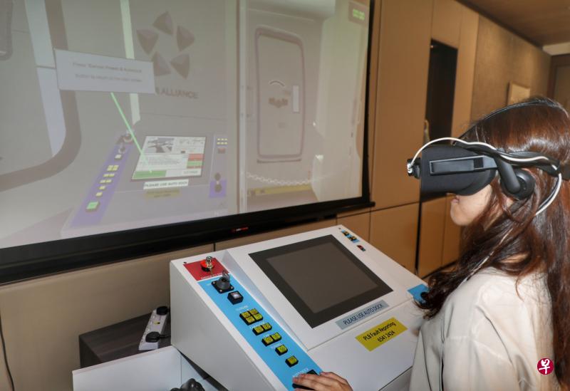 戴上虚拟实境“头盔”,宛如身临登机桥。樟宜机场集团和科技公司Aviation Virtual开发登机桥模拟器,希望可缩短相关的培训时间。(林国明摄) 戴上虚拟实境“头盔”,宛如身临登机桥。樟宜机场集团和科技公司Aviation Virtual开发登机桥模拟器,希望可缩短相关的培训时间。(林国明摄)