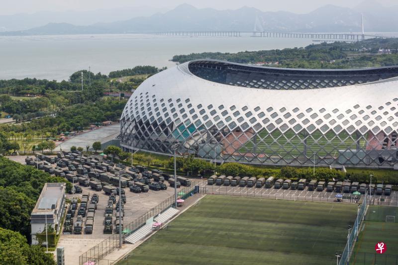 距离香港大约7公里、与香港只有一湾之隔的深圳湾体育中心外,昨天停驻了数十辆卡车和装甲运兵车。(路透社) 距离香港大约7公里、与香港只有一湾之隔的深圳湾体育中心外,昨天停驻了数十辆卡车和装甲运兵车。(路透社)