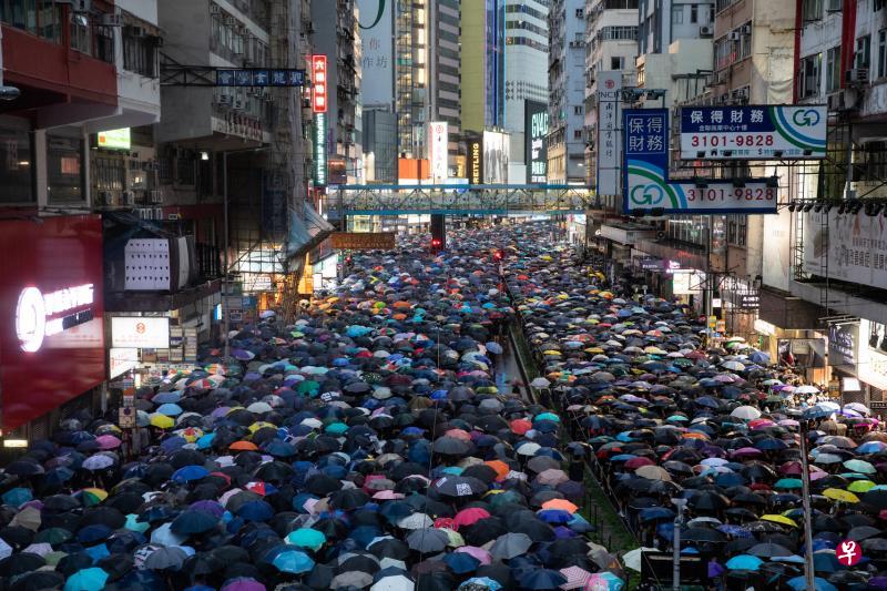 香港示威者昨天举行“止黑暴、制警乱”集会，昨天虽然下着雨，但是仍有大批港人出席这场“流水式”集会，五颜六色的雨伞覆盖了铜锣湾一带的街道。（彭博社）