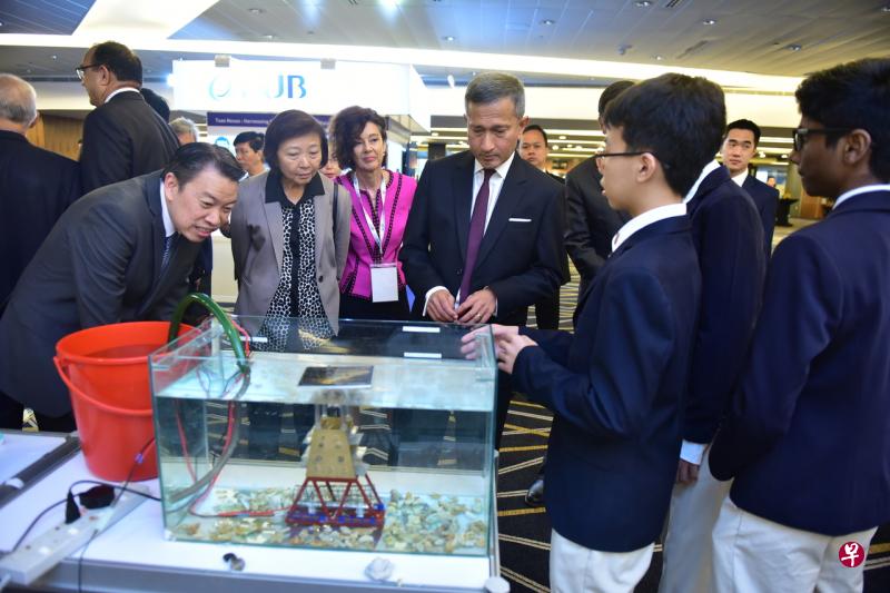 在工程创新挑战中获奖的新加坡科技中学学生,向出席2019世界工程师峰会的外交部长维文医生(右三)、全国职工总会助理秘书长、丹戎巴葛集选区议员杨益财(左起)、义顺集选区议员李美花以及新西兰驻新加坡最高专员乔·廷德尔,介绍他们制作的样机。这些学生研发的项目,是“促进珊瑚生长的光伏蓝光传输系统”。(新加坡工程学会提供) 在工程创新挑战中获奖的新加坡科技中学学生,向出席2019世界工程师峰会的外交部长维文医生(右三)、全国职工总会助理秘书长、丹戎巴葛集选区议员杨益财(左起)、义顺集选区议员李美花以及新西兰驻新加坡最高专员乔·廷德尔,介绍他们制作的样机。这些学生研发的项目,是“促进珊瑚生长的光伏蓝光传输系统”。(新加坡工程学会提供)