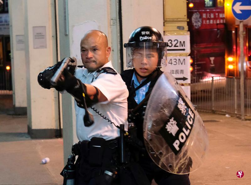 香港“光头警长”7月30日晚在港铁葵芳站外举起长枪与示威者对峙的照片让他走红大陆。(路透社) 香港“光头警长”7月30日晚在港铁葵芳站外举起长枪与示威者对峙的照片让他走红大陆。(路透社)