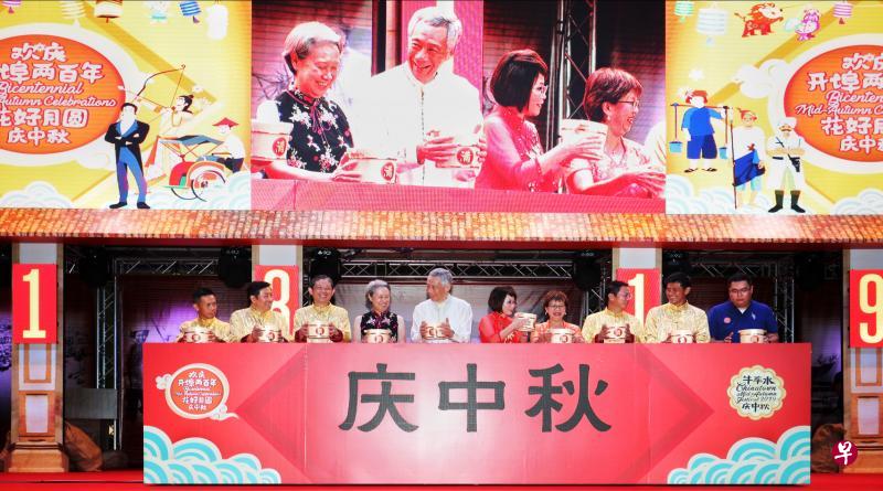 李显龙总理和夫人何晶(右六与七)昨晚为牛车水庆中秋活动“欢庆开埠两百年,花好月圆庆中秋”主持开幕仪式,将象征丰收的黄豆倒入平台内的仪器,启动亮灯装置。参与仪式的包括新加坡旅游局局长陈建隆(左起)、牛车水—金声公民咨询委员会主席罗海挥、牛车水庆中秋筹委会联合主席陈祖坤、惹兰勿刹集选区议员梁莉莉医生和潘丽萍、牛车水庆中秋筹委会联合主席白清富、人民协会总执行理事长陈国明,以及牛车水商联会主席梁文才。(林泽锐摄) 李显龙总理和夫人何晶(右六与七)昨晚为牛车水庆中秋活动“欢庆开埠两百年,花好月圆庆中秋”主持开幕仪式,将象征丰收的黄豆倒入平台内的仪器,启动亮灯装置。参与仪式的包括新加坡旅游局局长陈建隆(左起)、牛车水—金声公民咨询委员会主席罗海挥、牛车水庆中秋筹委会联合主席陈祖坤、惹兰勿刹集选区议员梁莉莉医生和潘丽萍、牛车水庆中秋筹委会联合主席白清富、人民协会总执行理事长陈国明,以及牛车水商联会主席梁文才。(林泽锐摄)
