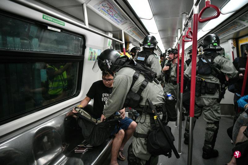 镇暴警察昨天下午在东涌线的列车车厢内检查乘客的随身物品。(法新社) 镇暴警察昨天下午在东涌线的列车车厢内检查乘客的随身物品。(法新社)