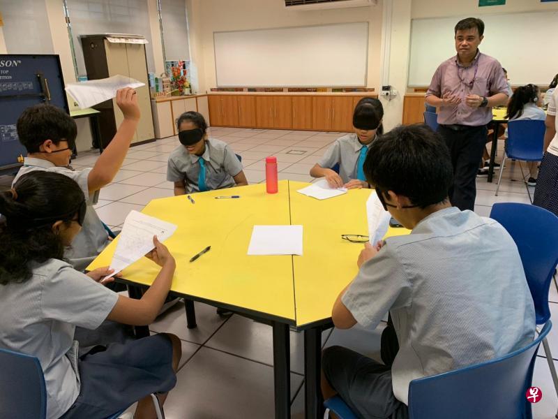 博文中学在中二的品德与公民教育课试行不一样的分班安排,来自不同源流的学生一同交流,在这堂课蒙眼折纸飞机,从中培养同理心。(博文中学提供) 博文中学在中二的品德与公民教育课试行不一样的分班安排,来自不同源流的学生一同交流,在这堂课蒙眼折纸飞机,从中培养同理心。(博文中学提供)