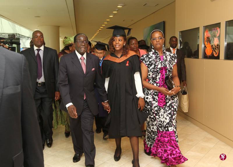 津巴布韦前总统穆加贝(左一)与妻子葛瑞丝(右一)曾在2013年到新加坡莱佛士城会议中心参加女儿波娜(中)的大学毕业典礼。波娜在新加坡管理发展学院(MDIS)修得硕士学位。(档案照片) 津巴布韦前总统穆加贝(左一)与妻子葛瑞丝(右一)曾在2013年到新加坡莱佛士城会议中心参加女儿波娜(中)的大学毕业典礼。波娜在新加坡管理发展学院(MDIS)修得硕士学位。(档案照片)