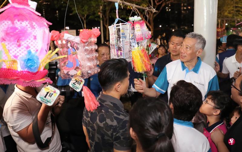 李显龙总理昨晚到碧山——宏茂桥公园与居民一同提灯笼环绕公园,也到灯笼展示处欣赏居民制作的得奖灯笼。(陈来福摄) 李显龙总理昨晚到碧山——宏茂桥公园与居民一同提灯笼环绕公园,也到灯笼展示处欣赏居民制作的得奖灯笼。(陈来福摄)