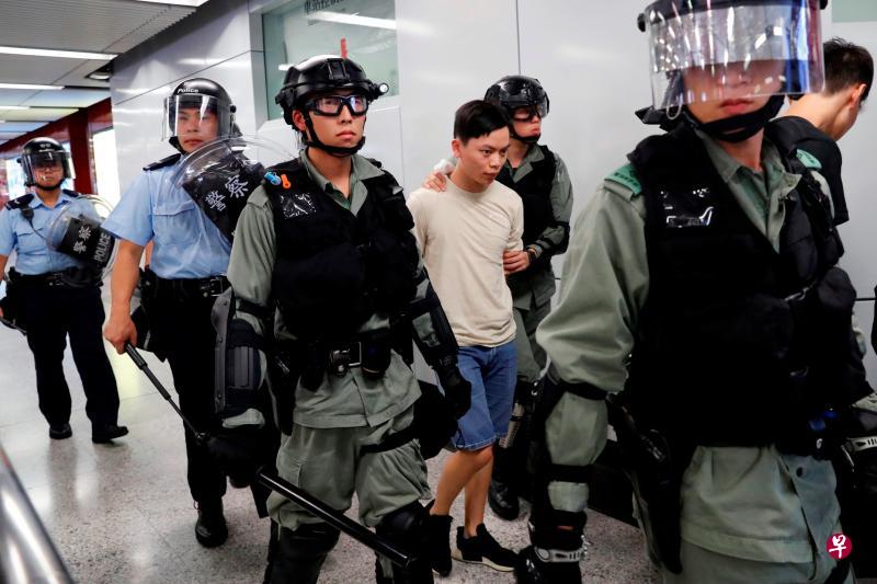 香港警察上星期天在地铁站里拘捕一名示威者，后面两名警员手持伸缩警棍。（路透社）