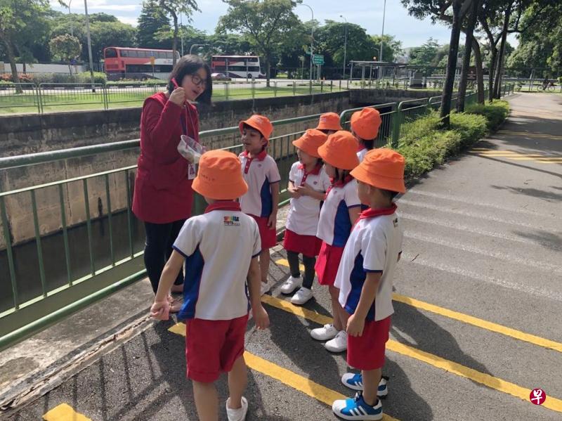 位于先驱的人民行动党社区基金会Sparkletots幼儿园教师陈秋爱,向孩童示范如果使用自制的取水工具,将沟渠的水取出,以进行观察。这项活动是该幼儿园其中一项户外学习项目。(受访者提供) 位于先驱的人民行动党社区基金会Sparkletots幼儿园教师陈秋爱,向孩童示范如果使用自制的取水工具,将沟渠的水取出,以进行观察。这项活动是该幼儿园其中一项户外学习项目。(受访者提供)