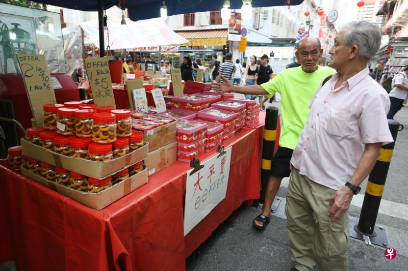 牛车水中秋市集摊贩赶在中秋节这天向顾客大力推销促销食品,希望尽快清完手上的货。(林明顺摄) 牛车水中秋市集摊贩赶在中秋节这天向顾客大力推销促销食品,希望尽快清完手上的货。(林明顺摄)