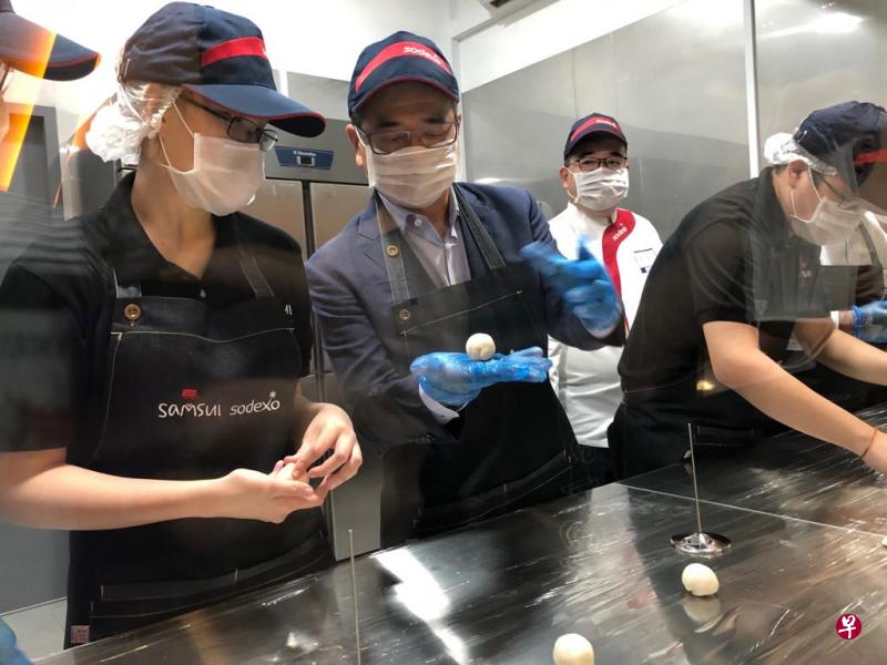 卫生部兼律政部高级政务部长唐振辉(左二)走访新协立综合设施的三水客勤培训务中心培训厨房,同接受餐饮服务在职培训的特需青年一起制作莲蓉包。(三水和索迪斯提供) 卫生部兼律政部高级政务部长唐振辉(左二)走访新协立综合设施的三水客勤培训务中心培训厨房,同接受餐饮服务在职培训的特需青年一起制作莲蓉包。(三水和索迪斯提供)