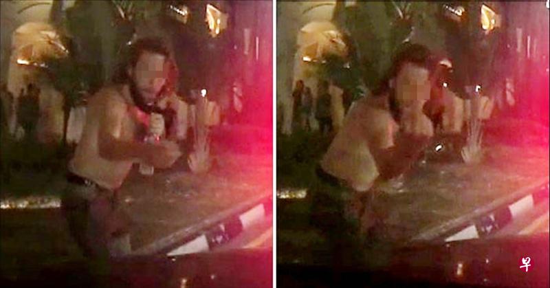 手持酒瓶的洋汉站在轿车前,比出中指并要求司机“捐款” 。( 取自STOMP) 手持酒瓶的洋汉站在轿车前,比出中指并要求司机“捐款” 。( 取自STOMP)