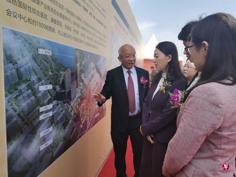 鹏瑞利首席执行长潘锡源（左）陪同昆明市人民政府副市长周红斌参观动土仪式上区域医疗保健和商业中心项目展览。（鹏瑞利置地提供）