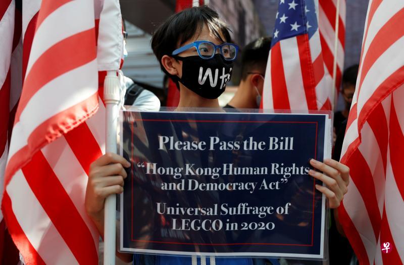 一名香港反修例示威者上周五(20日)参加一场集会时举牌呼吁美国国会通过《香港人权与民主法案》。(路透社) 一名香港反修例示威者上周五(20日)参加一场集会时举牌呼吁美国国会通过《香港人权与民主法案》。(路透社)