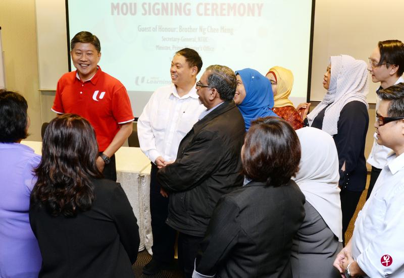 总理公署部长兼全国职工总会秘书长黄志明(红衣者)与新加坡保险雇员联合会秘书长许永威(后排左二)在签署仪式上和保险业者交谈。(潘丰源摄) 总理公署部长兼全国职工总会秘书长黄志明(红衣者)与新加坡保险雇员联合会秘书长许永威(后排左二)在签署仪式上和保险业者交谈。(潘丰源摄)