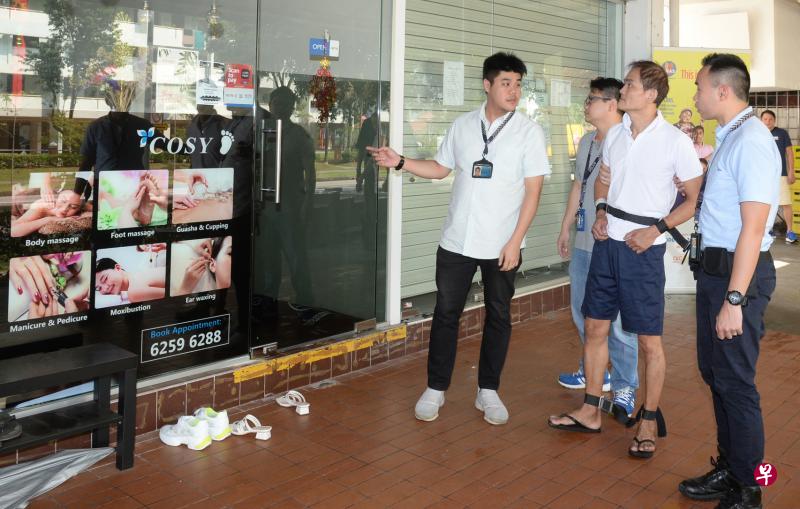 宏茂桥按摩院抢劫案的一名被告星期一被押回现场,他在店外回答警员提问。(潘丰源摄) 宏茂桥按摩院抢劫案的一名被告星期一被押回现场,他在店外回答警员提问。(潘丰源摄)