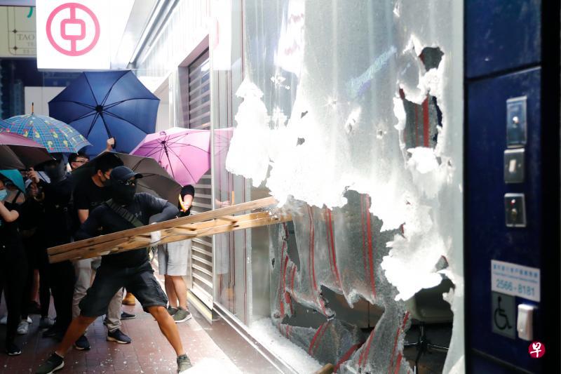 香港的抗争者打砸旺角一家中国银行支行。(路透社) 香港的抗争者打砸旺角一家中国银行支行。(路透社)