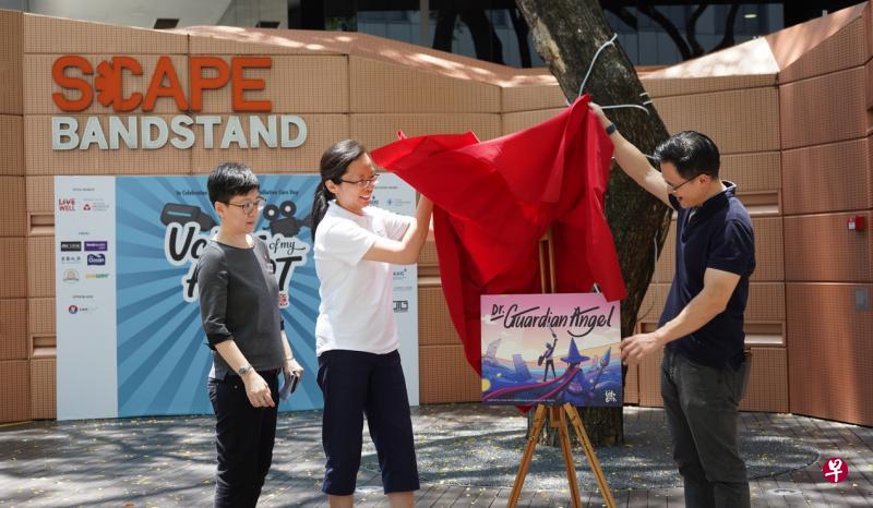 东北区市长朱倍庆（右一）在新加坡慈怀理事会举办的“艺心一意”活动上，推介生命书籍系列中的第三本绘册《我的守护天使》。（新加坡慈怀理事会提供）