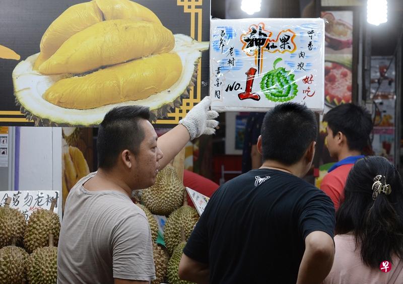 店家指这组游客吃的是名为“神仙果”的顶级黑金榴梿。(潘丰源摄) 店家指这组游客吃的是名为“神仙果”的顶级黑金榴梿。(潘丰源摄)