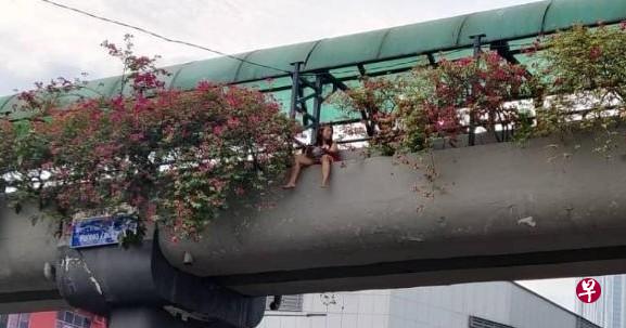 一名华族女子周四上午坐在新山一座行人天桥护栏外企图自杀。她被消防员劝动并打消自杀念头后,还转而约消防员吃早餐。(星洲日报) 一名华族女子周四上午坐在新山一座行人天桥护栏外企图自杀。她被消防员劝动并打消自杀念头后,还转而约消防员吃早餐。(星洲日报)