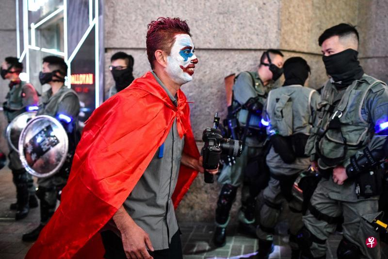 图为一名化妆成小丑的年轻人,昨天傍晚在兰桂坊走过警察防线。(法新社) 图为一名化妆成小丑的年轻人,昨天傍晚在兰桂坊走过警察防线。(法新社)