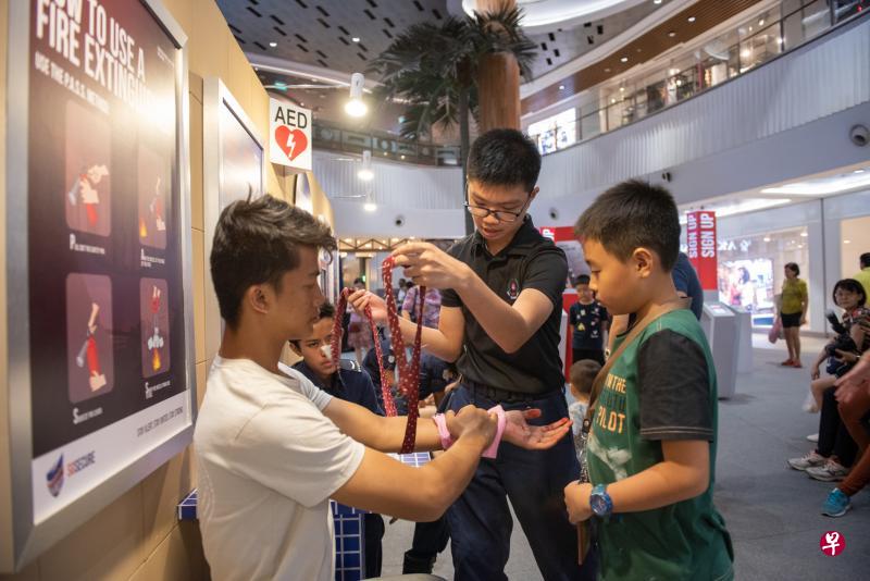 在为期三天的全国保家安民计划路演上,公众可学习到不同急救技能,如使用领带等日常用品,以捆绑方式止血。(特约陈佳誉摄) 在为期三天的全国保家安民计划路演上,公众可学习到不同急救技能,如使用领带等日常用品,以捆绑方式止血。(特约陈佳誉摄)