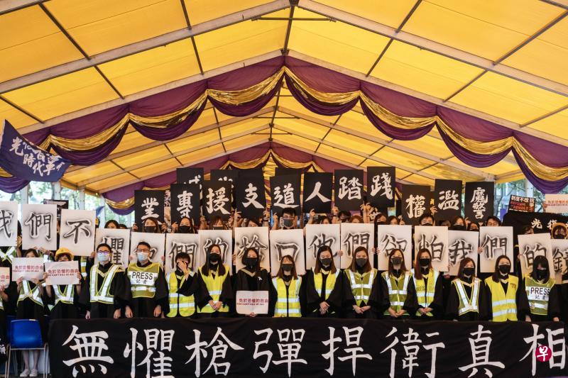 中大毕业礼奏国歌期间,大批毕业生背向主礼台站立,高举标语并大喊口号,声浪甚至盖过国歌音乐。(彭博社) 中大毕业礼奏国歌期间,大批毕业生背向主礼台站立,高举标语并大喊口号,声浪甚至盖过国歌音乐。(彭博社)