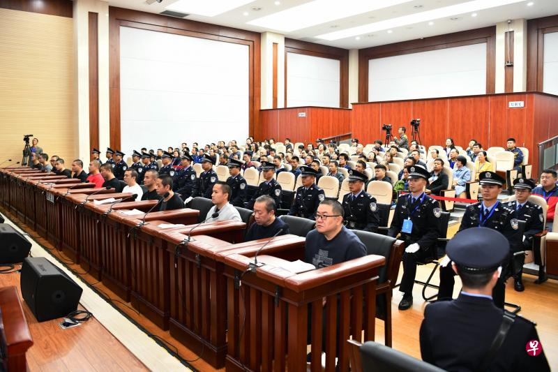“昆明恶霸”孙小果（前排右一）和另外12名涉案被告前天在法院中受审。（新华社）