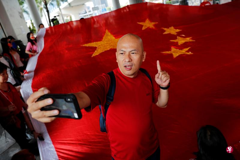 今年10月1日,杨官华在香港庆祝中国70周年国庆,与中国国旗合影。(路透社) 今年10月1日,杨官华在香港庆祝中国70周年国庆,与中国国旗合影。(路透社)