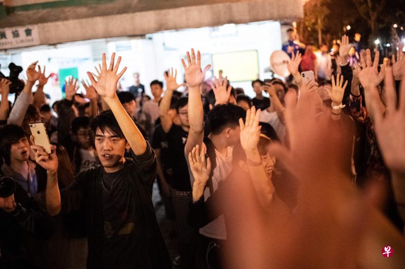 香港泛民支持者今天凌晨在屯门获知建制派候选人何君尧落选后,庆祝一番。(法新社) 香港泛民支持者今天凌晨在屯门获知建制派候选人何君尧落选后,庆祝一番。(法新社)