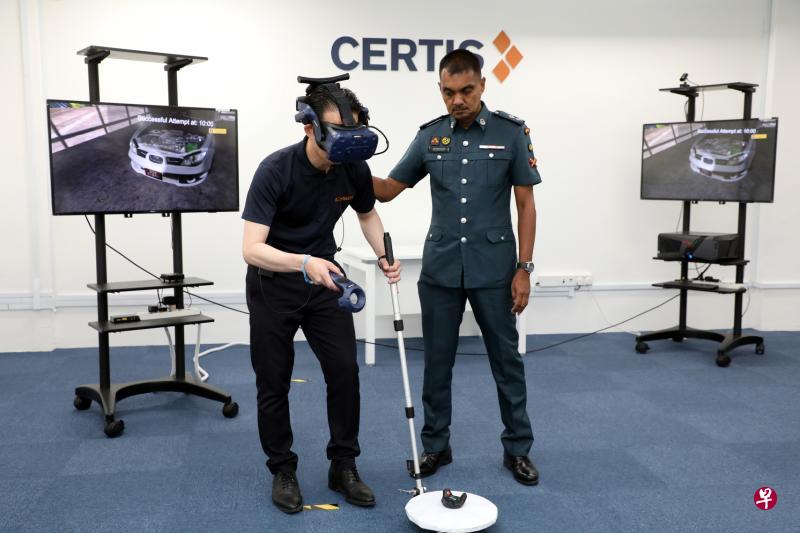策安集团的保安员(左)在教官指导下,戴着虚拟实境眼镜,练习检查车辆是否藏有可疑物件。(邝启聪摄) 策安集团的保安员(左)在教官指导下,戴着虚拟实境眼镜,练习检查车辆是否藏有可疑物件。(邝启聪摄)