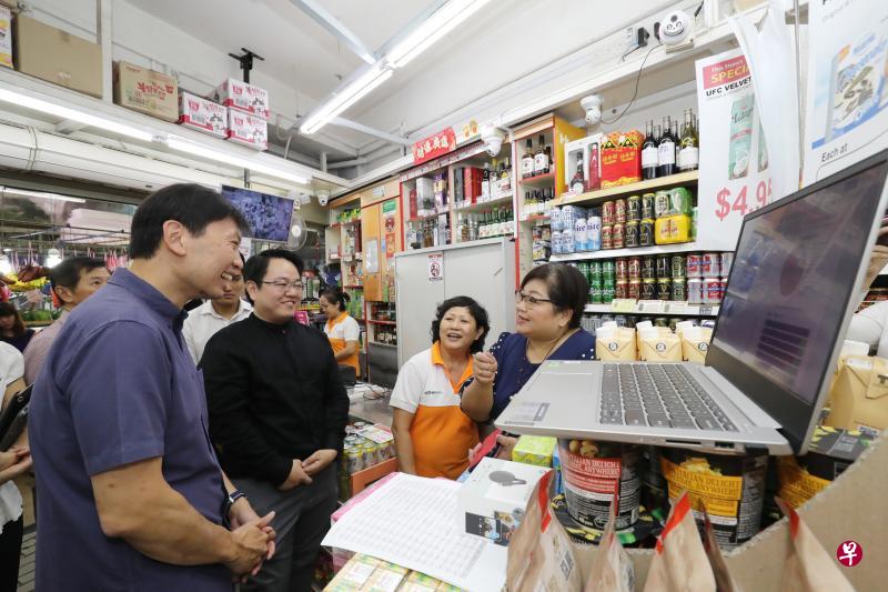 贸工部兼教育部高级政务部长徐芳达(左)向迷你超市店主了解如何通过数码化改变经营方式。(陈来福摄) 贸工部兼教育部高级政务部长徐芳达(左)向迷你超市店主了解如何通过数码化改变经营方式。(陈来福摄)