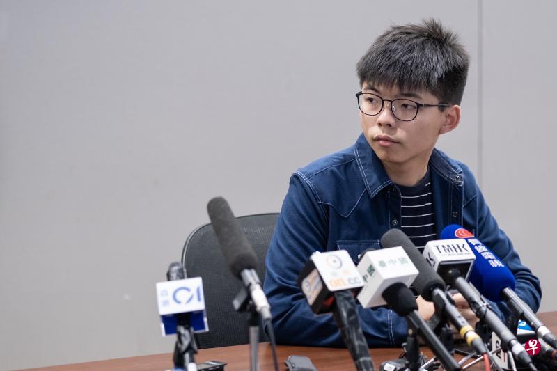 黄之峰在香港举行的记者会上听取媒体的提问。(彭博社) 黄之峰在香港举行的记者会上听取媒体的提问。(彭博社)