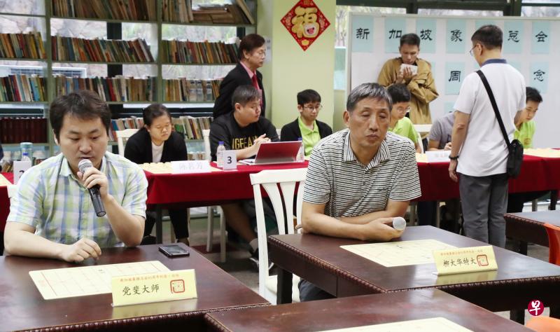 柳大华(前右)与党斐(前左)闭目与背后六名年轻棋手对弈,左后方站立观察赛事者为象总会长林关浩。(陈来福摄) 柳大华(前右)与党斐(前左)闭目与背后六名年轻棋手对弈,左后方站立观察赛事者为象总会长林关浩。(陈来福摄)