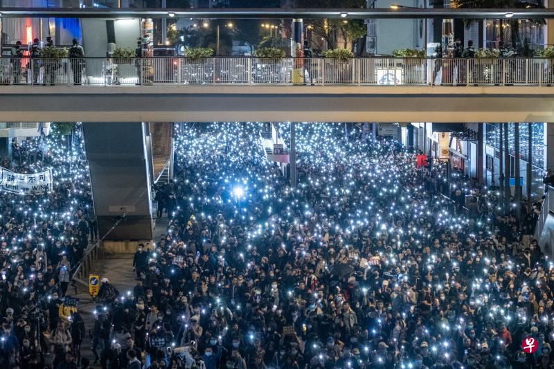 香港民阵昨天发起“国际人权日”大游行,数以十万计港人走上街头,在途经湾仔区轩尼诗道时亮起手机灯光,桥上警员高度戒备。(彭博社) 香港民阵昨天发起“国际人权日”大游行,数以十万计港人走上街头,在途经湾仔区轩尼诗道时亮起手机灯光,桥上警员高度戒备。(彭博社)